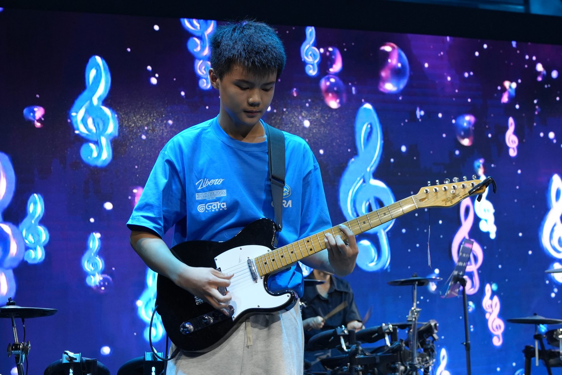 Yixuan performing electric guitar on stage